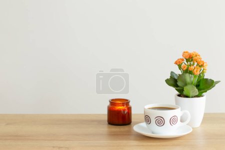 Téléchargez les photos : Plante de la maison, bougie brûlante et tasse de café sur fond mur gris - en image libre de droit