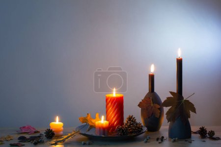Photo for Autumn dark decor with candles on wooden shelf on background wall - Royalty Free Image