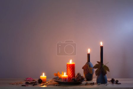 Foto de Otoño decoración oscura con velas en estante de madera en la pared de fondo - Imagen libre de derechos