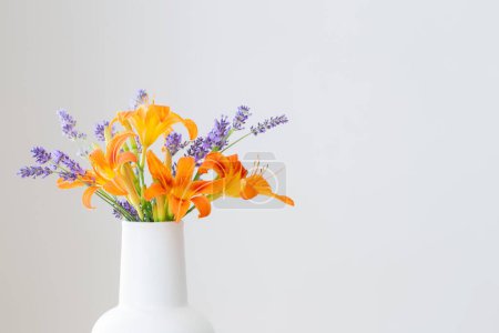 Foto de Flores de verano en jarra blanca en estante de madera - Imagen libre de derechos