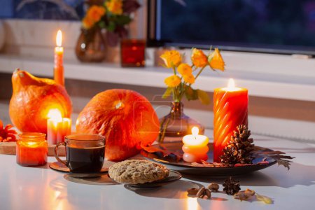 Téléchargez les photos : Nature morte d'automne avec des citrouilles, des bougies brûlantes et une tasse de thé - en image libre de droit