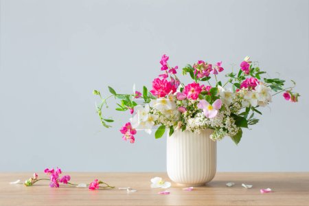 Photo for Summer flowers in ceramic cup on light background - Royalty Free Image