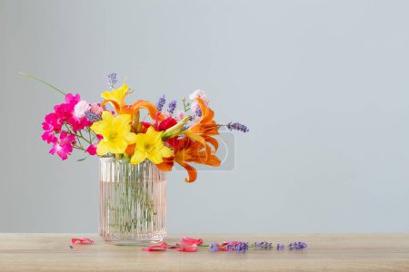 Photo for Summer flowers in glass vase on wooden shelf - Royalty Free Image