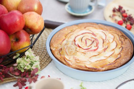 Téléchargez les photos : Tarte aux pommes sur la table posée dans le jardin le jour ensoleillé - en image libre de droit