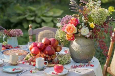 Foto de Tarta de manzana en la mesa puesta en el jardín en el día soleado - Imagen libre de derechos