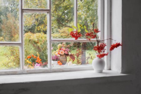 Photo for Rowan berries in white vase on old white windowsill - Royalty Free Image