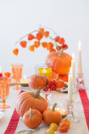 Foto de Mesa de otoño con velas encendidas y calabazas - Imagen libre de derechos