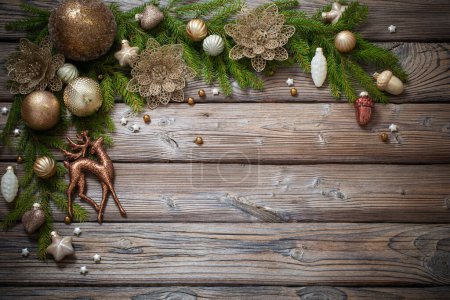 Photo for Golden christmas toys with fir branches on dark wooden background - Royalty Free Image