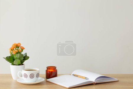Photo for Still life with house plant, notepad, pen and coffee cup in modern interior - Royalty Free Image