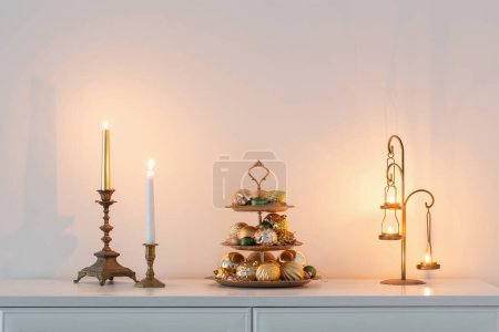 Photo for Christmas golden decor with burning candles in white interior - Royalty Free Image