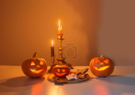 Photo for Halloween pumpkins with burning candles on white table - Royalty Free Image