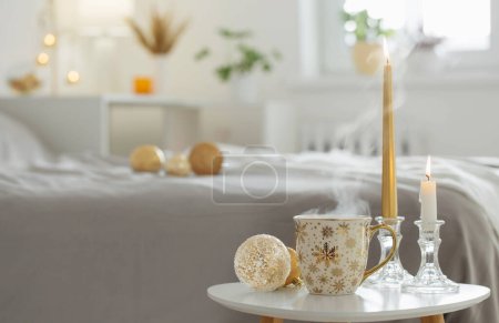 Téléchargez les photos : Tasse de café avec boules de Noël sur petite table dans la chambre blanche - en image libre de droit