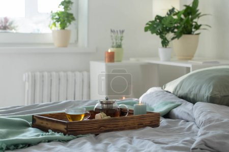 Photo for Tea on wooden tray on bed at home - Royalty Free Image