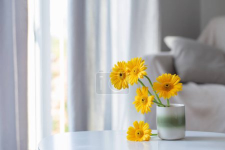 Photo for Yellow gerbera in ceramic vase in light living room - Royalty Free Image