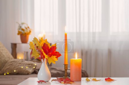 Téléchargez les photos : Bougies allumées avec décor d'automne sur table blanche à la maison - en image libre de droit