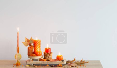 Photo for Autumn decor with burning candles on wooden shelf - Royalty Free Image