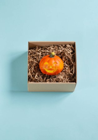 Photo for Halloween pumpkin in gift box on blue background - Royalty Free Image