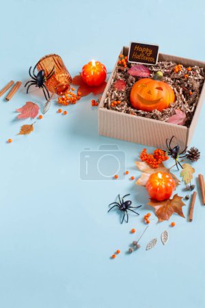 Téléchargez les photos : Citrouille d'Halloween en boîte cadeau avec décor sur fond bleu - en image libre de droit
