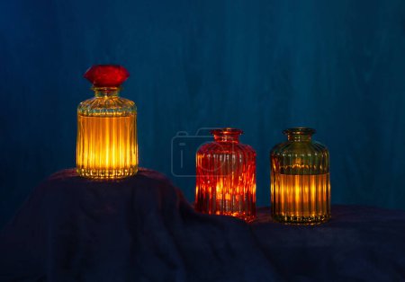 Foto de Pociones mágicas brillantes en botellas de vidrio sobre fondo oscuro - Imagen libre de derechos