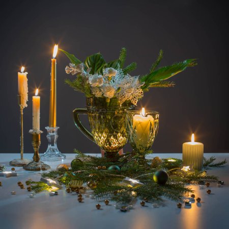 Photo for Christmas still life with branch of fir, candles and lights - Royalty Free Image