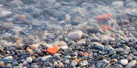 Téléchargez les photos : Pierre rouge en forme de coeur sur la plage par la mer - en image libre de droit