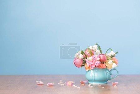 Photo for Beautiful spring flowers in vintage cup in pastel colors on blue background - Royalty Free Image