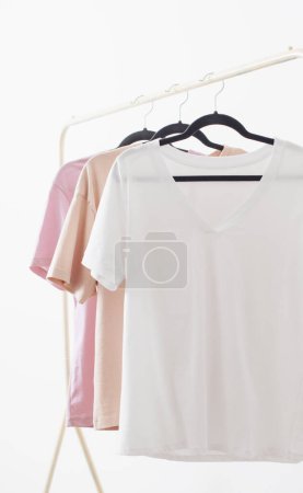 Foto de Camisetas de mujer en percha sobre fondo blanco - Imagen libre de derechos