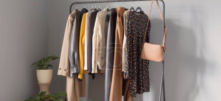 Photo for Basic women's autumn wardrobe with shoes and handbags on  hanger - Royalty Free Image