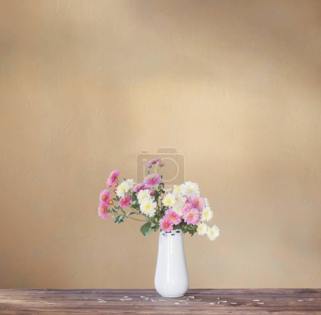 Photo for Chrysanthemums in  vase on old wooden table - Royalty Free Image