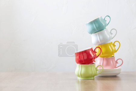 Téléchargez les photos : Groupe de différentes tasses sur table en bois sur fond blanc - en image libre de droit