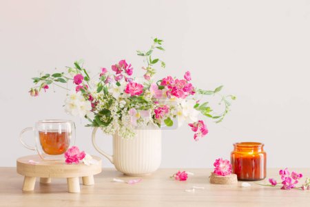 Photo for Summer flowers, burning candles and cup of tea   on light background - Royalty Free Image