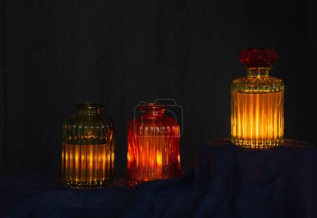 Foto de Pociones mágicas brillantes en botellas de vidrio sobre fondo oscuro - Imagen libre de derechos