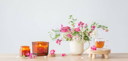 Photo for Summer flowers, burning candles and cup of tea   on light background - Royalty Free Image