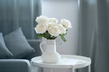 Foto de Ramo de rosas blancas en jarra blanca en el interior moderno - Imagen libre de derechos