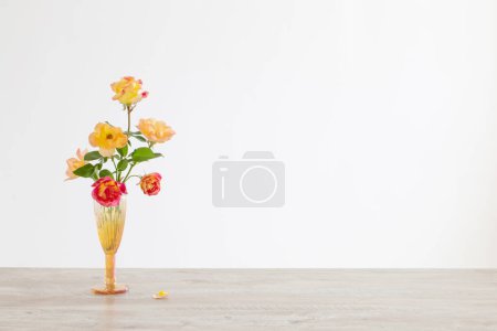 Téléchargez les photos : Roses orange et rose dans un vase en verre à l'intérieur blanc - en image libre de droit