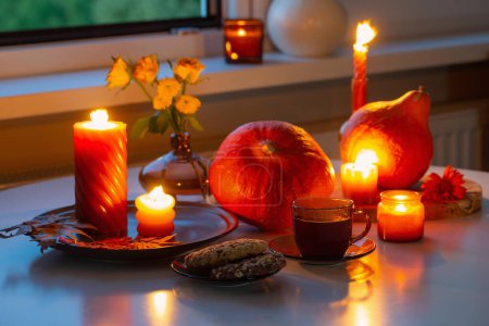 Foto de Naturaleza muerta de otoño con calabazas, velas encendidas y taza de té - Imagen libre de derechos