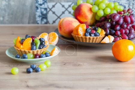 Foto de Magdalenas con frutas en la mesa de madera en la cocina - Imagen libre de derechos