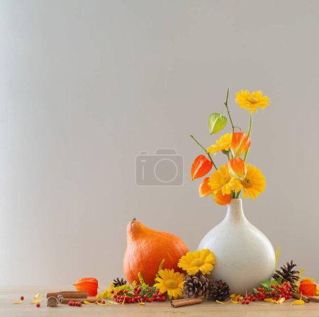 Foto de Bodegón otoñal con flores, conos, bayas en estante de madera - Imagen libre de derechos