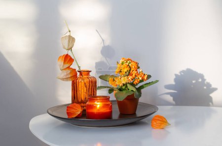 Photo for Autumnal still life with flowers and candles, on white table - Royalty Free Image