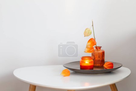 Foto de Bodegón otoñal con flores y velas, sobre mesa blanca - Imagen libre de derechos