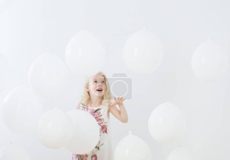Foto de Niña con globos blancos en el interior - Imagen libre de derechos