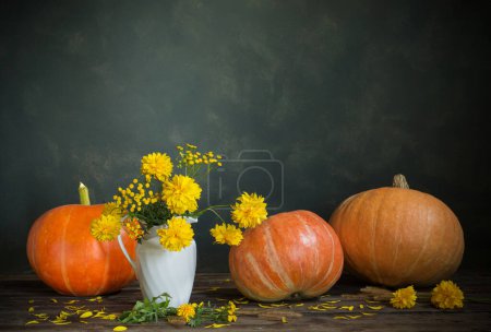 Foto de Bodegón con flores amarillas y calabazas sobre una vieja mesa de madera - Imagen libre de derechos