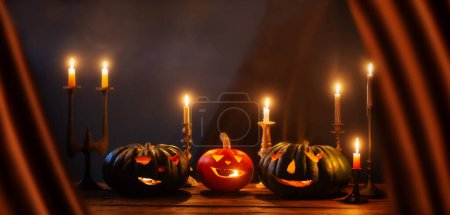 Foto de Calabazas de Halloween con velas encendidas sobre fondo oscuro - Imagen libre de derechos