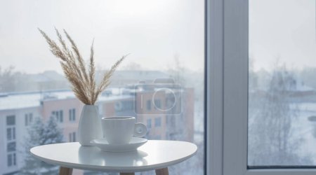 Téléchargez les photos : Tasse de café sur table blanche par fenêtre en hiver - en image libre de droit