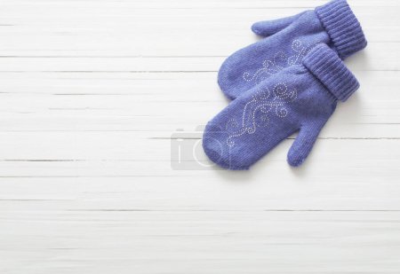 Photo for Purple  mittens on white wooden background - Royalty Free Image