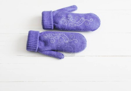 Photo for Purple mittens on white wooden background - Royalty Free Image