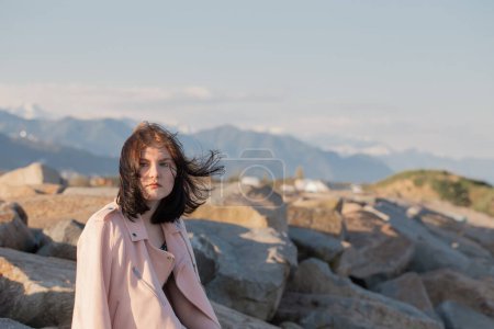 Foto de Mujer joven en chaqueta rosa sobre fondo montañas paisaje - Imagen libre de derechos