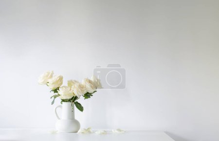 Photo for Bouquet of white roses in jug on white background - Royalty Free Image