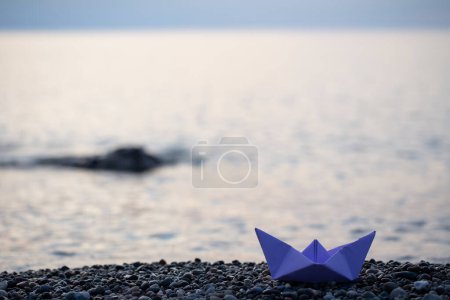 Photo for Paper boat by the sea at sunset - Royalty Free Image