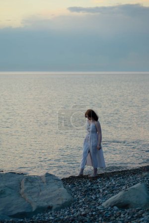 Téléchargez les photos : Jeune fille par la mer au coucher du soleil - en image libre de droit
